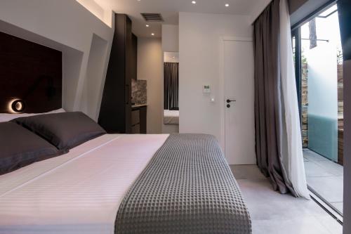 a bedroom with a large bed and a large window at Sylvia Camping & Luxury Suites, Panel Hospitality Homes & Villas in Litochoro