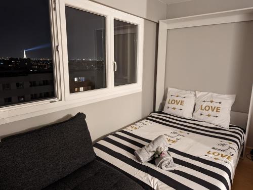 une chambre avec un lit et une fenêtre avec des coussins d'amour dans l'établissement Charming Studio with Eiffel View, à Paris