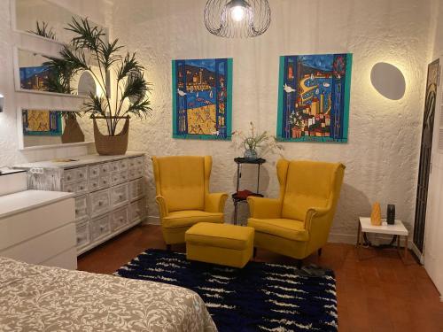- une chambre avec deux chaises jaunes et un lit dans l'établissement Picasso Walk Cosy charm in heart of Old Town Antibes AC and WiFi, à Antibes