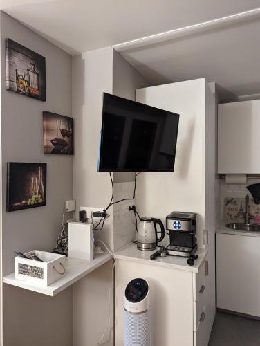 un salon avec une télévision sur un mur dans l'établissement Charming Studio with Eiffel View, à Paris