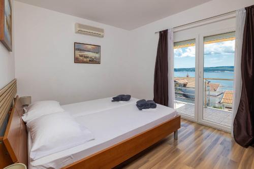 a bedroom with a bed and a large window at NOVOSELIC 7 Penthaus in Dramalj
