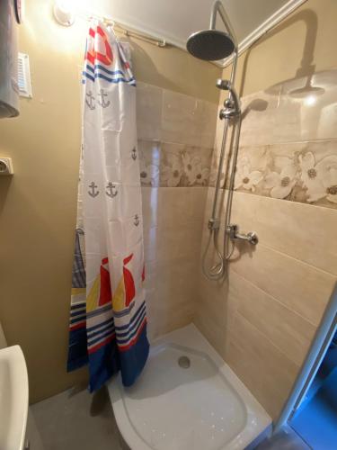 a bathroom with a shower and a toilet with a shower curtain at Bezvējš in Jūrmala