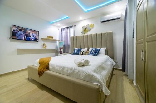 a bedroom with a bed with a tv on the wall at Casa acogedora in Santiago de los Caballeros