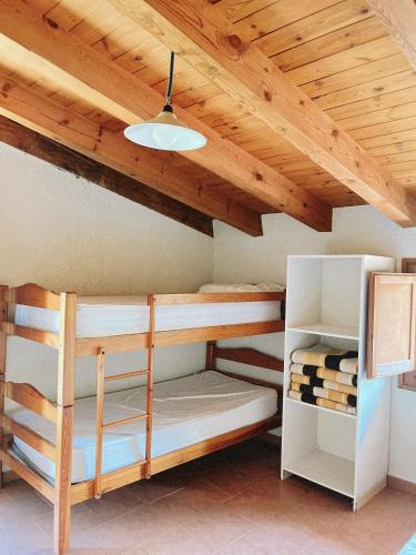 a room with bunk beds and a wooden ceiling at Alberg rural torre del baró in Sant Llorenc de Morunys