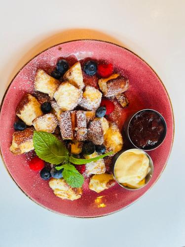 een rode kom met eten, bosbessen en brood bij Nadmorskie Tarasy Pink&Blue - Apartament C215 Sea&Sun in Kołobrzeg