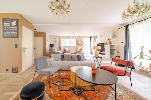 un salon avec un canapé et une table dans l'établissement Villa 200m2 cosy au calme avec baignoire balnéo, à Saint-Ouen-les-Vignes