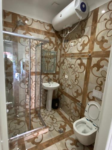 a bathroom with a shower and a toilet and a sink at DEJA BLUE Cozy Apartments in Durrës