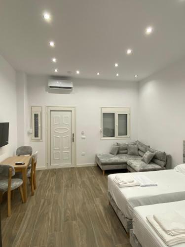 a bedroom with two beds and a table and a couch at DEJA BLUE Cozy Apartments in Durrës