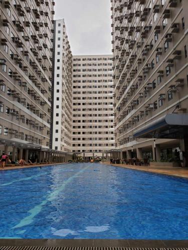 a swimming pool in front of two tall buildings at Cavite RAF Condotel in Dasmariñas