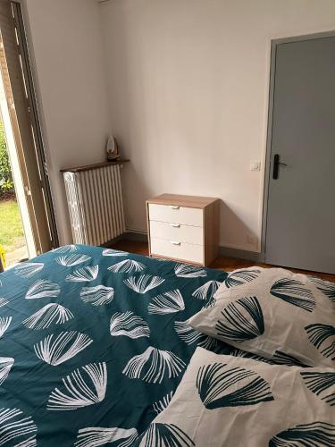 une chambre avec un lit avec une couverture bleue et blanche dans l'établissement Appartement à Boulogne Billancourt proche de Paris, à Boulogne-Billancourt