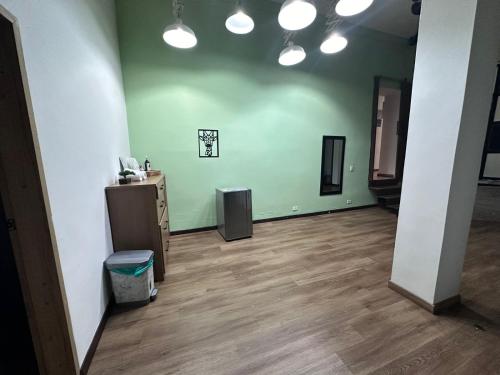an empty room with green walls and wooden floors at Soy Local Primavera in Medellín