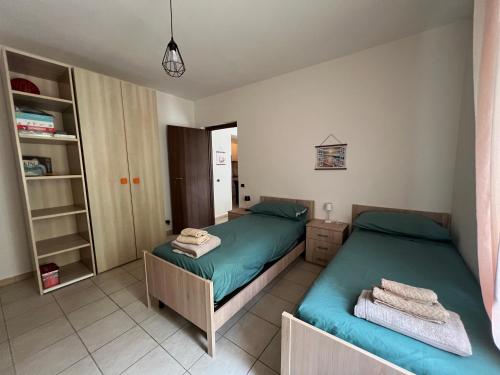 a bedroom with two beds and a closet at Hollydom in Marina di Fuscaldo