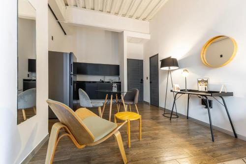 a dining room and living room with a table and chairs at Capitalia Centro Historico in Mexico City