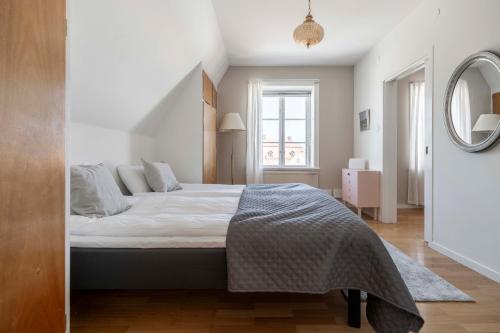 a bedroom with a bed and a mirror at Loft gem situated in the heart of Visby in Visby