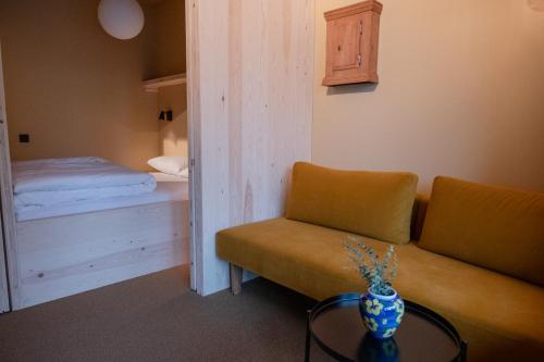 a living room with a couch and a bed at Trolltun Hotel & Hytter in Dombås