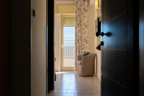 a view of a room with a chair and a window at Hotel Garden in Praia a Mare