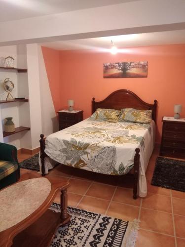 ein Schlafzimmer mit einem Bett in einem Zimmer mit orangefarbenen Wänden in der Unterkunft Casa Gama in Ribeira da Janela