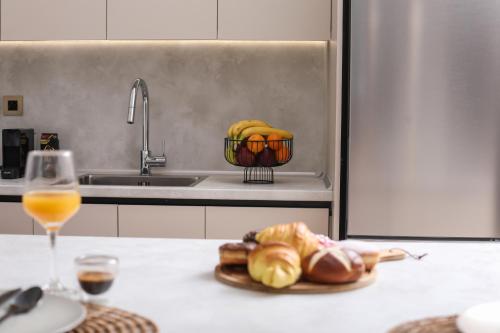 a kitchen counter with a basket of fruit and a glass of wine at Olive Luxury Suite in Agios Rokkos