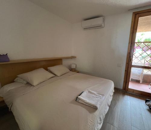 a bedroom with a large white bed with a window at VALENTINA HOME Costa Smeralda Vista Mar in Cugnana Verde