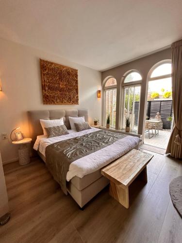 a bedroom with a large bed and a large window at ZEN b&b in Dordrecht