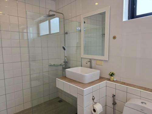 a white bathroom with a sink and a mirror at The Joy Private Pool Villa in Chiang Mai
