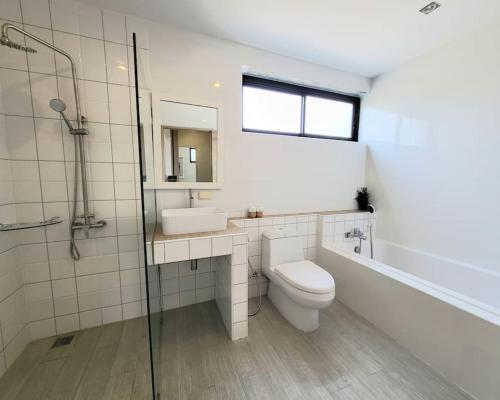 a bathroom with a toilet and a sink and a shower at The Joy Private Pool Villa in Chiang Mai