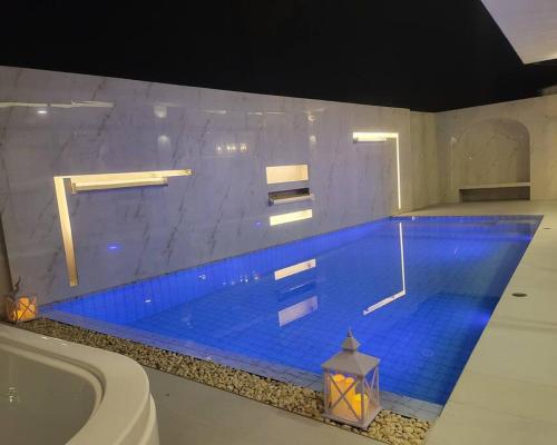 a large swimming pool with blue water in a bathroom at The Joy Private Pool Villa in Chiang Mai