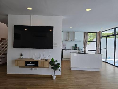 a living room with a flat screen tv on a wall at The Joy Private Pool Villa in Chiang Mai
