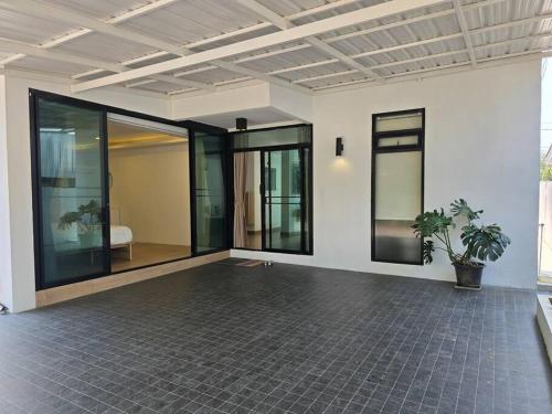 an empty room with glass doors and a plant at The Joy Private Pool Villa in Chiang Mai