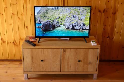 a flat screen tv sitting on top of a wooden cabinet at Wood House Berat in Berat