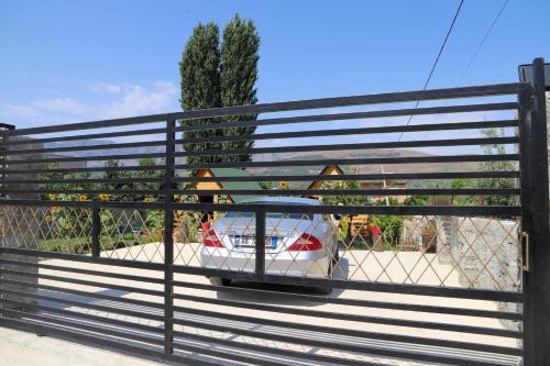 a gate with a car parked behind a fence at Wood House Berat in Berat