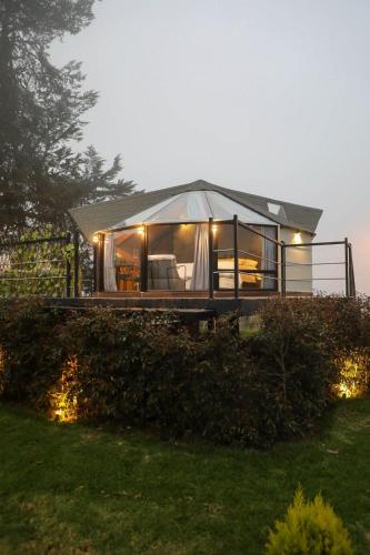 a large glass house with a roof at Glamping Al Pie del Cerro in San Fernando