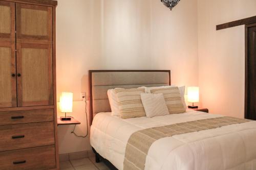 Un dormitorio con una cama y dos lámparas sobre mesas. en San Cayetano 3 with AC just a block away from the main square, en San Miguel de Allende