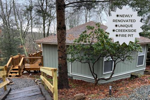 a small green house with a sign in front of it at The Beech Hut in Beech Mountain