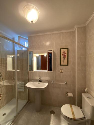 a bathroom with a sink and a toilet and a shower at Apartamento con vistas al mar playa Berria-Santoña in Santoña