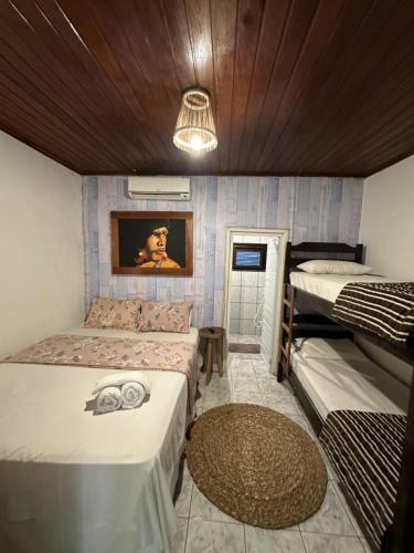 a room with three beds and a ceiling at Pousada Isabel Araújo in Jericoacoara