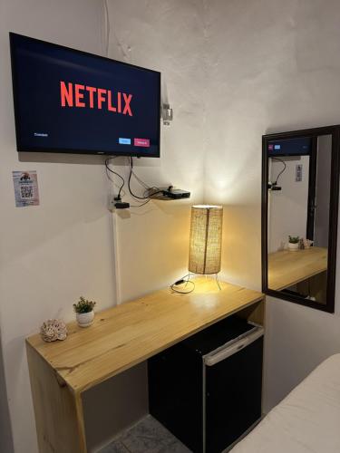 a desk with a television on a wall at Pousada Isabel Araújo in Jericoacoara