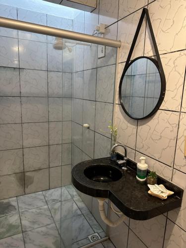 a bathroom with a black sink and a mirror at Pousada Isabel Araújo in Jericoacoara