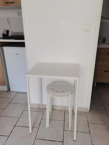 une petite table blanche et un tabouret dans une cuisine dans l'établissement Studio 1 - Métro Europe Rouen, à Rouen