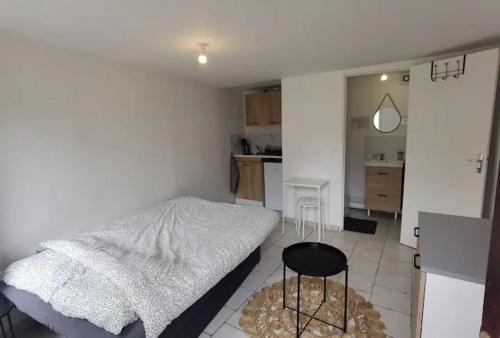 une chambre avec un lit et une table et une cuisine dans l'établissement Studio 1 - Métro Europe Rouen, à Rouen