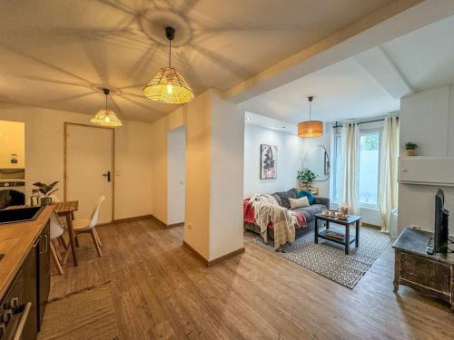 a living room with a couch and a bed in a room at Élégance au Cœur de Tarbes in Tarbes