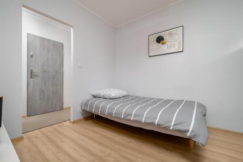 a bedroom with a bed in a white room at Apartament Stella in Częstochowa