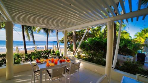 a table on a balcony with a view of the beach at Elegant Beachfront Studio in Monarca Ixtapa in Ixtapa
