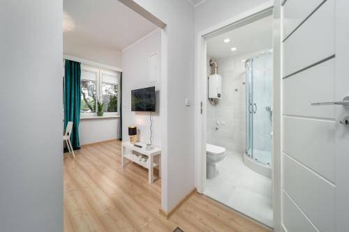 a white bathroom with a toilet and a sink at Apartament Stella in Częstochowa