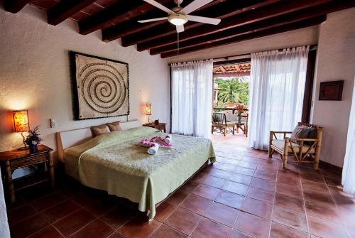 une chambre avec un lit et un ventilateur de plafond dans l'établissement Punta Marina Casa 7, à Zihuatanejo