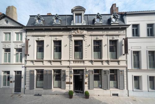 a large white building with windows and doors at Cobergher Hotel in Kortrijk