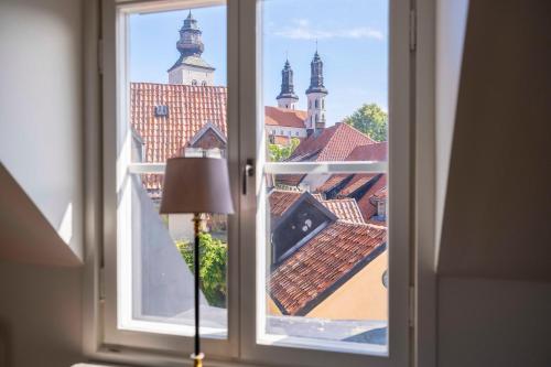 a window with a view of the roofs of a building at Cozy 3 -bedroom apartment in middle of Visby in Visby