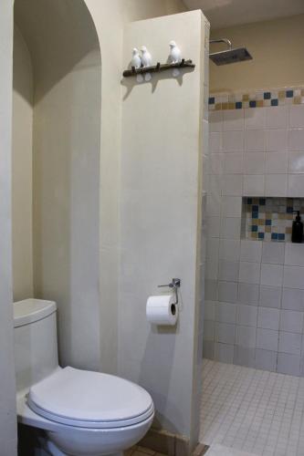 a bathroom with a toilet and a toilet paper dispenser at The Urban Nest - Cozy Studio with AC in San Miguel de Allende