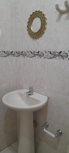 ein Badezimmer mit Waschbecken und Spiegel an der Wand in der Unterkunft HOSTAL CARACOLI - HUECO in Valledupar