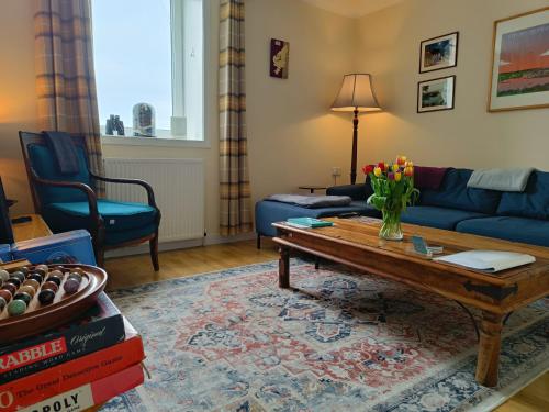 a living room with a couch and a coffee table at Snowberry Cottage in Borve